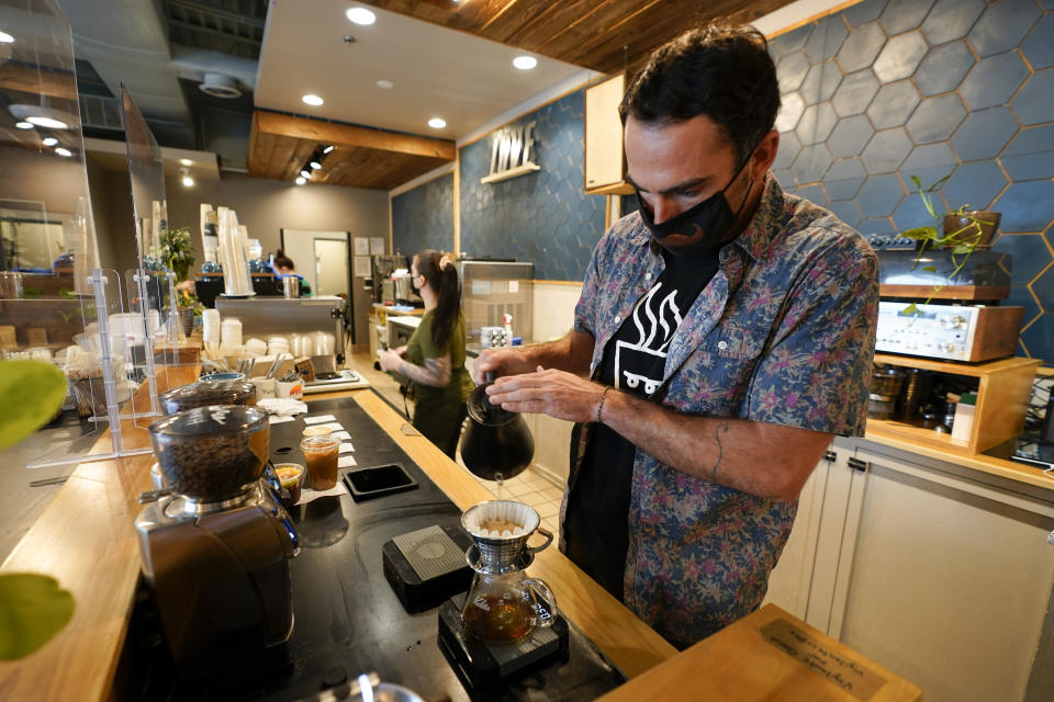 Chris Vigilante makes a dripped coffee for a customer at one of his coffee shops, Wednesday, Sept. 1, 2021, in College Park, Md. A confluence of supply chain problems, drought, frost and inflation all point to the price of your cup of morning coffee going up. (AP Photo/Julio Cortez)