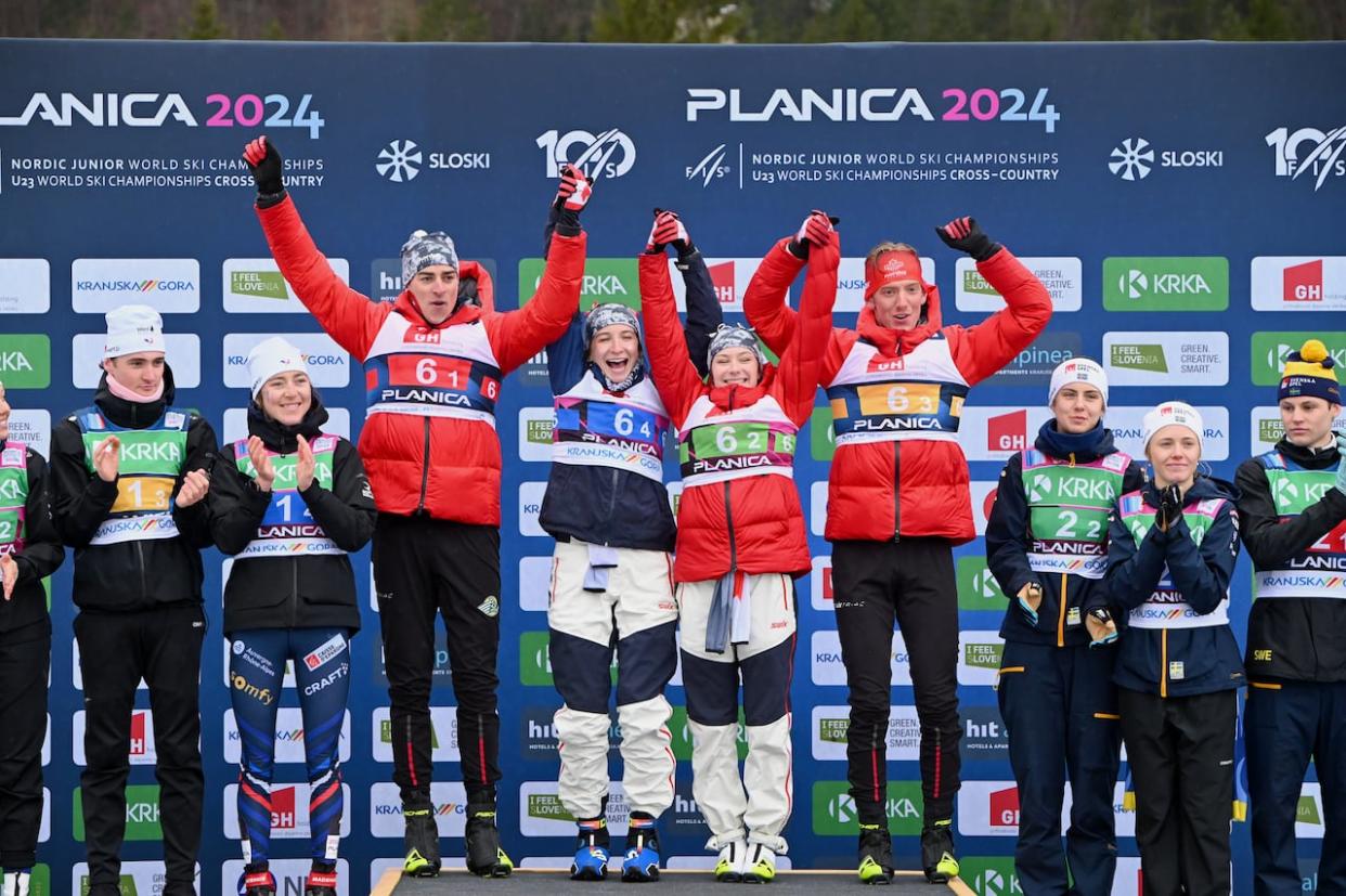 From left: Canada's Derek Deuling, Liliane Gagnon, Jasmine Drolet and Max Hollmann celebrate on the podium after winning Sunday's mixed relay event at the world under-23 cross-country ski championships in Planica, Slovenia. (Ziga Zivulovic Jr./BOBO and OneSkate Photos via The Canadian Press - image credit)