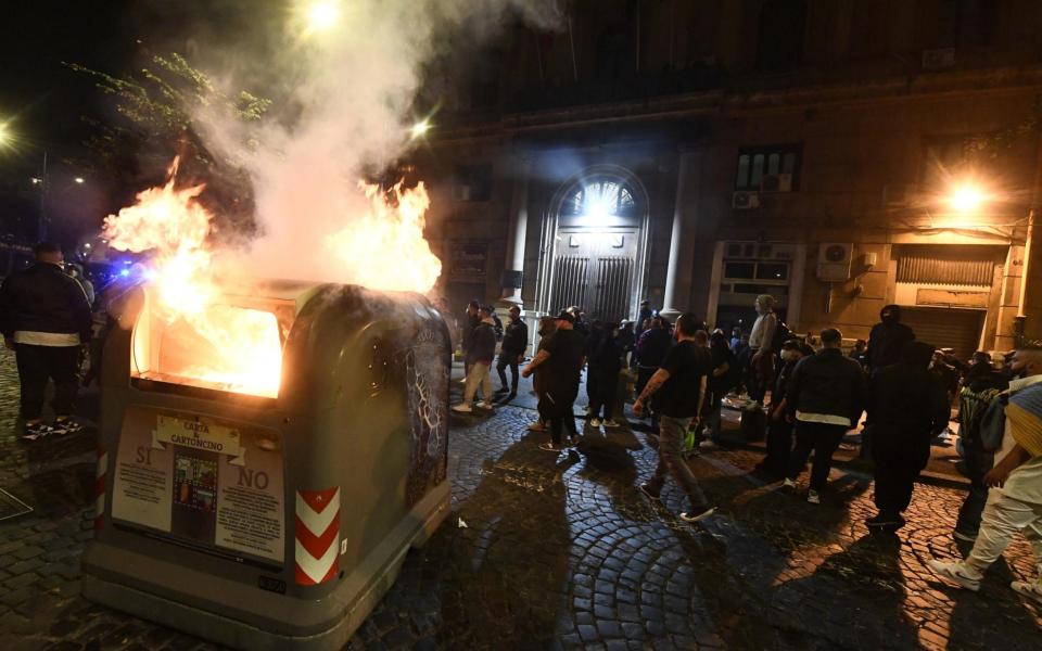 A garbage can set on fire in front of the Campania Region headquarters during the protest  - STRINGER/EPA-EFE/Shutterstock