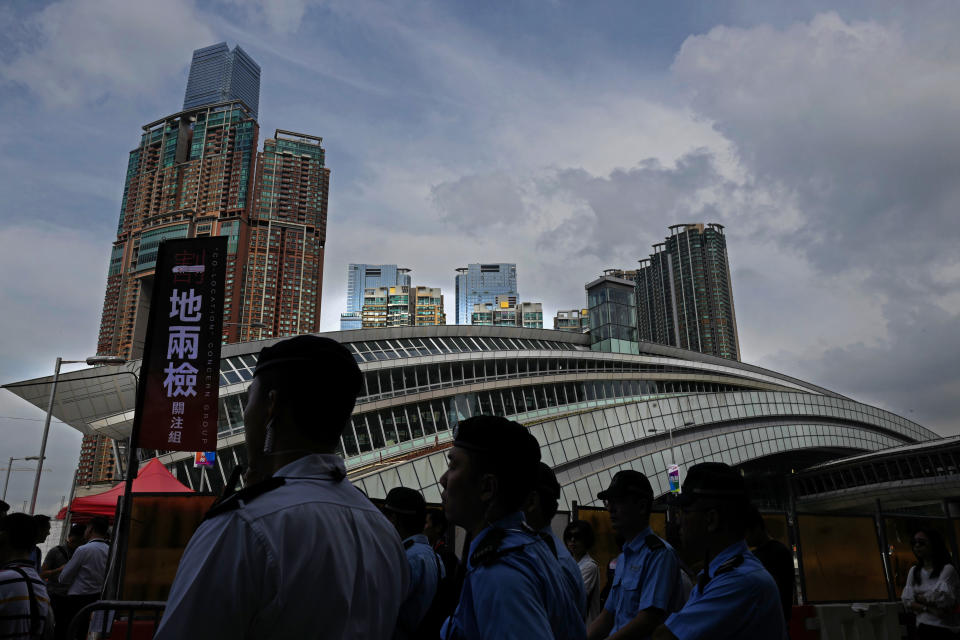 Police officers stand guard outside the Western Kowloon Station during a protest against the opening ceremony of the Hong Kong Express Rail Link in Hong Kong, Saturday, Sept. 22, 2018. Hong Kong has opened a new high-speed rail link to inland China that will vastly decrease travel times but which also raises concerns about Beijing's creeping influence over the semi-autonomous Chinese region. (AP Photo/Vincent Yu)