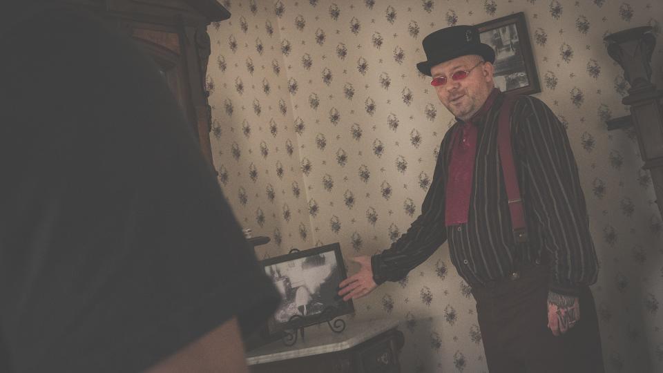 Tour guide Jack Sheridan shows guests a crime scene photo of Abby Borden in the room where she died.