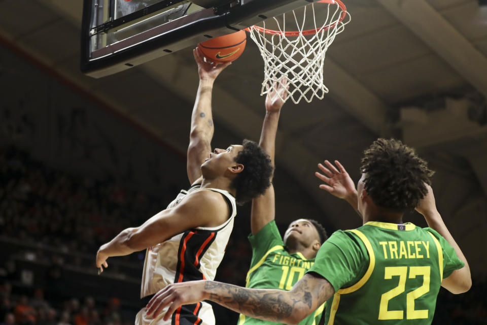 Oregon State forward Michael Rataj, left, drives to the basket as Oregon forward Kwame Evans Jr., center, and guard Jadrian Tracey defend during the first half of an NCAA college basketball game Saturday, Feb. 17, 2024, in Corvallis, Ore. (AP Photo/Amanda Loman)