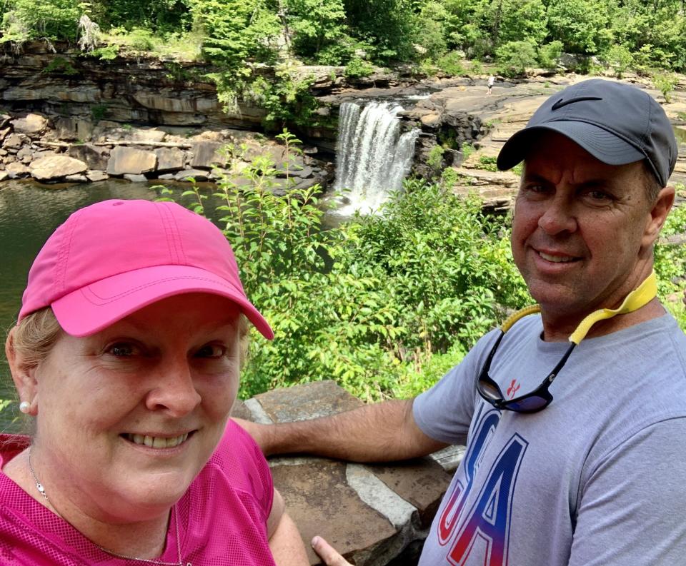 Suzy and Steve Leonard pose for a photo in front of the waterfall before hiking to the bottom of Little River Canyon in Alabama.