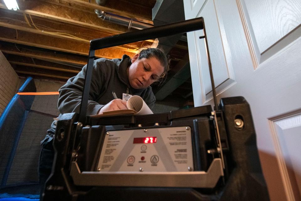 Menold employee Angie Semon writes down her findings while doing a temperature check for a home in Washington on Nov. 22, 2021.