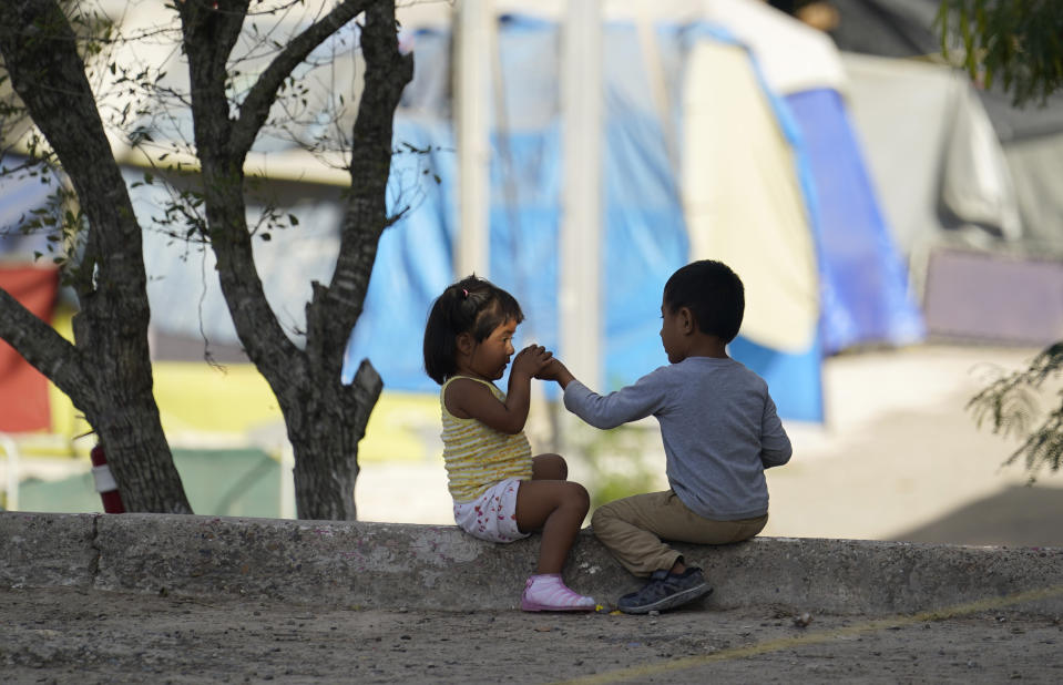 FILE - In this Tuesday, Nov. 18, 2020, file photo, children play at a camp of asylum seekers stuck at America's doorstep, in Matamoros, Mexico. Increasing numbers of parents and children are crossing the border, driven by violence and poverty in Central America and growing desperation in migrant camps in Mexico. U.S. Customs and Border Protection said Monday, Dec. 14, 2020 that it made 4,592 apprehensions of unaccompanied immigrant children in November, more than six times the figure in April. (AP Photo/Eric Gay File)