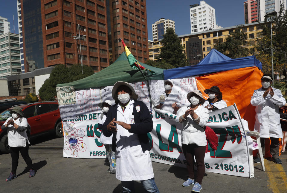 Trabajadores de salud protestan frente a las oficinas del Ministerio de la Salud el viernes 29 de mayo de 2020, en La Paz, Bolivia, en demanda de que se contrate a más doctores para enfrentar la pandemia y que les den mejores condiciones laborales. (AP Foto/Juan Karita)