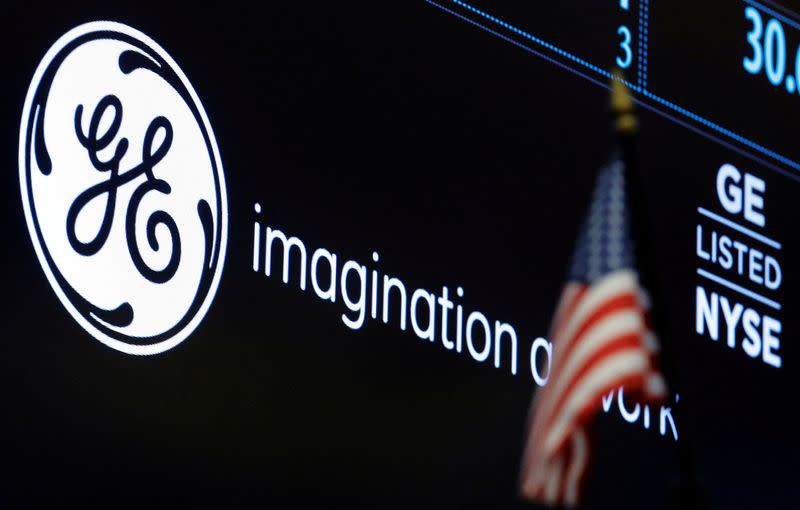 FILE PHOTO: The ticker and logo for General Electric Co. is displayed on a screen at the post where it's traded on the floor of the NYSE
