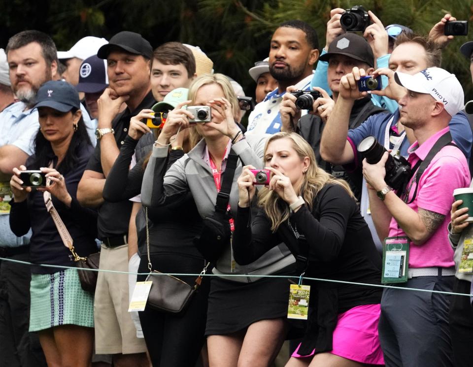 Fans take photos of Tiger Woods as he plays a practice round at Augusta National on April 9.