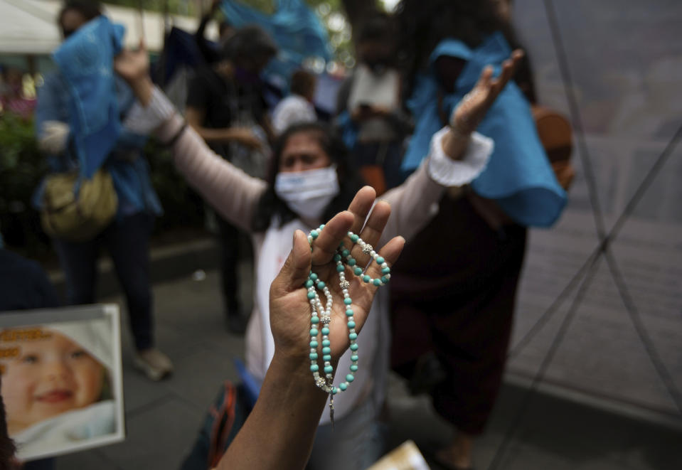 A woman clutches a rosary as she celebrates the Supreme Court's decision against an injunction in Veracruz state that aimed to decriminalize abortion for all cases within the first 12 weeks of pregnancy outside the Supreme Court in Mexico City, Wednesday, July 29, 2020. Two of Mexico’s 32 states have decriminalized abortion. (AP Photo/Fernando Llano)