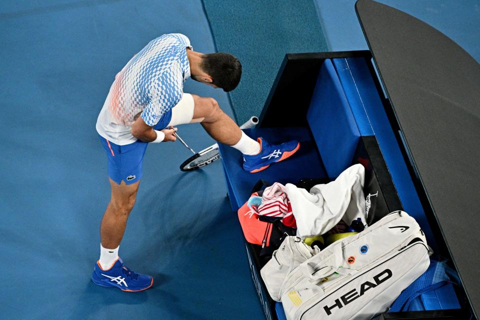 Seen here, Serbia's Novak Djokovic adjusts his bandage as he competes against France's Enzo Couacaud in the second round of the Australian Open. 