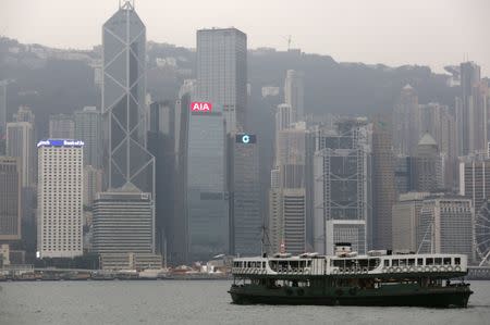 FILE PHOTO: A ferry sails at Victoria Harbour in front of the financial Central district, featuring AIA Central (C) and Cheung Kong Center behind it, in Hong Kong, China February 17, 2016. REUTERS/Bobby Yip/File Photo