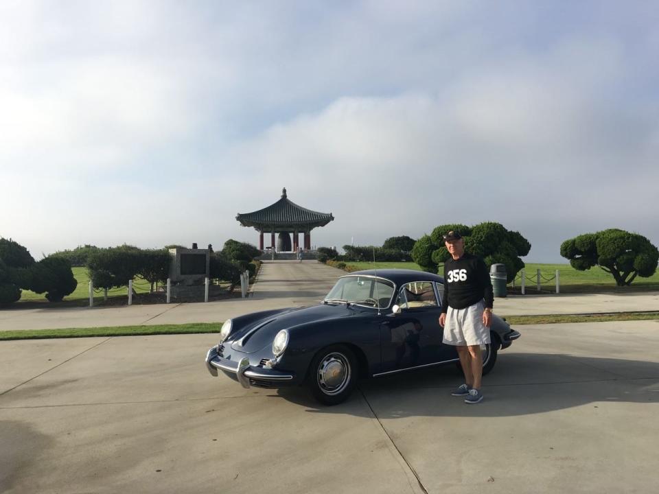 Guy Newmark with his 1964 Porsche 356 at the Korean Bell monument in the San Pedro section of Los Angeles. He has driven the car more than 1.1 million miles.