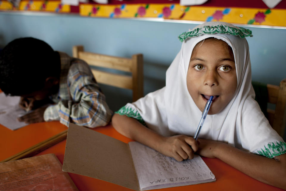 In this Monday, Feb. 24, 2014, Pakistani students take notes during class at a charity school founded by Humaira Bachal, in Karachi, Pakistan. At the age of 13, Bachal began teaching other girls what she learned in school. Those classes at home between friends grew into her life’s work: Bringing education to children in the working-class Muwach Goth neighborhood on the outskirts of Pakistan’s port city of Karachi, where families often keep their girls out of school and where even boys struggle to get decent learning. (AP Photo/Shakil Adil)