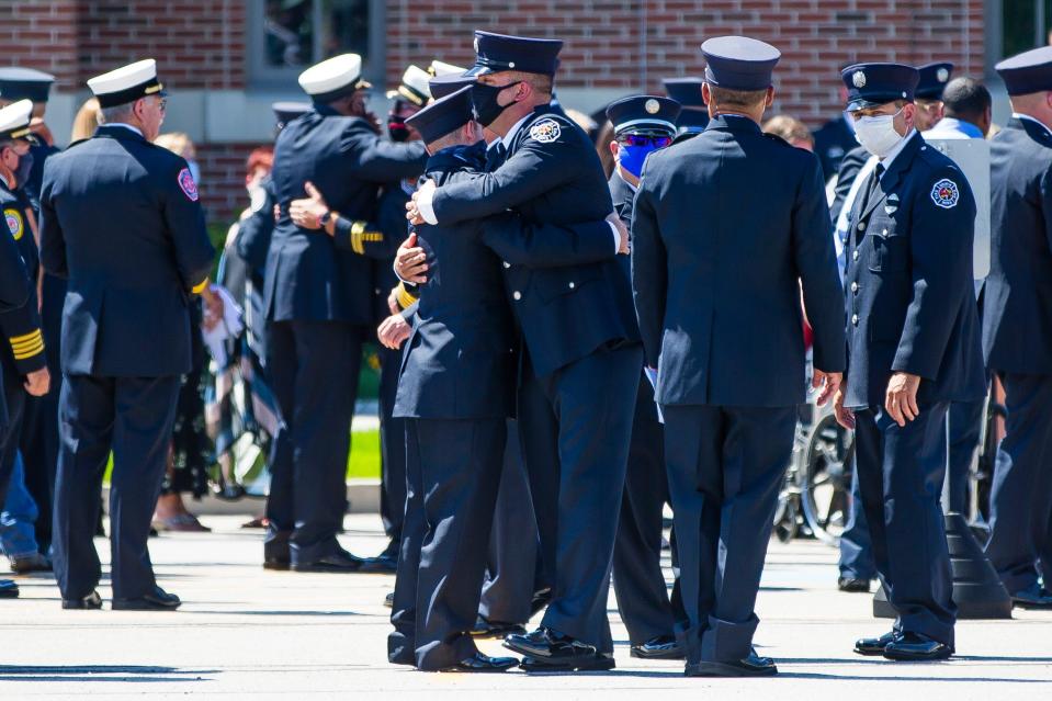 Attendees embrace one another Wednesday after the funeral for South Bend Firefighter Jeremy Bush at Saint Pius X Catholic Church in Granger.