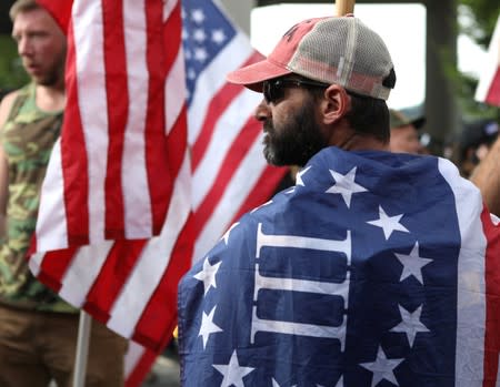 A supporter wears a flag at a Proud Boys rally in Portland, Oregon