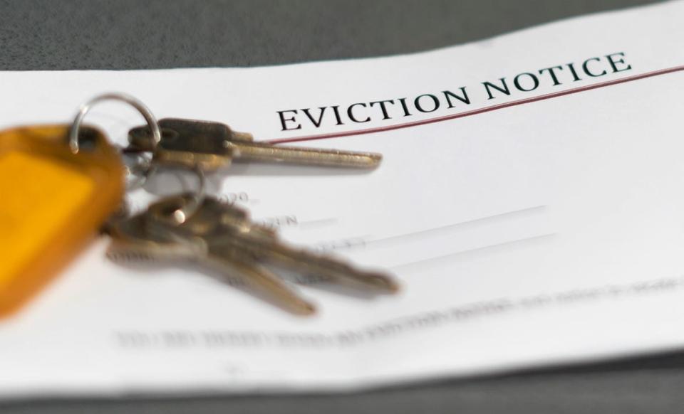 House keys sitting on an eviction notice received in the mail.