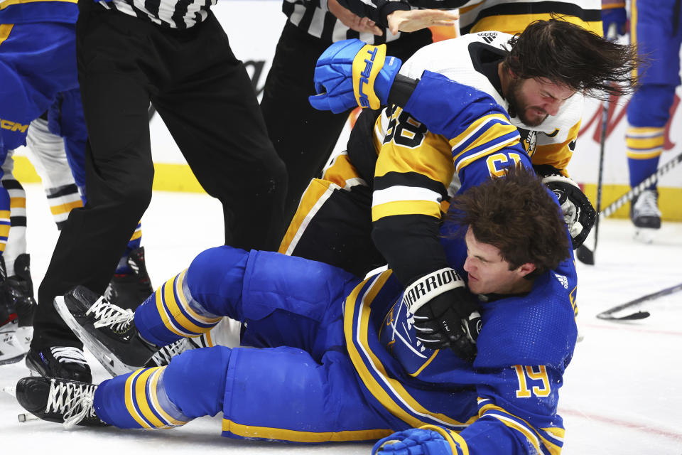 Buffalo Sabres center Peyton Krebs (19) is wrestled to the ice by Pittsburgh Penguins defenseman Kris Letang (58) during the second period of an NHL hockey game Friday, Nov. 24, 2023, in Buffalo N.Y. (AP Photo/Jeffrey T. Barnes)