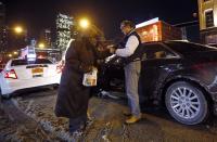 En esta ocasión Patrick Angelo ayuda a una mujer que vive en la calle a ponerse unos guantes que le acaba de entregar. REUTERS/Jim Young