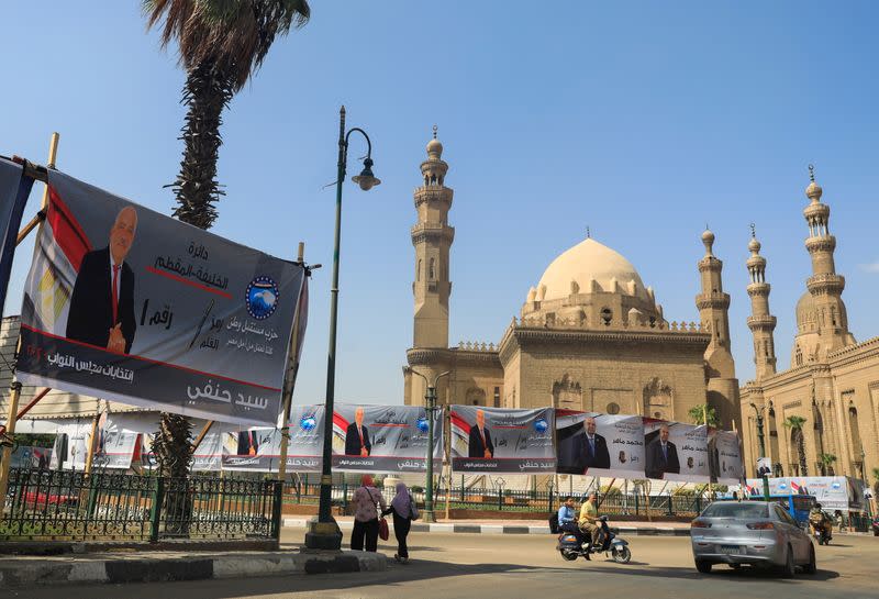 People and traffic are seen under election campaign banners of Mostaqbal Watn (Nation's Future) around minarets of Sultan Hassan Mosque and the Al-Rifa'i Mosque before the first round of the parliamentary election at a highway in old Islamic Cairo