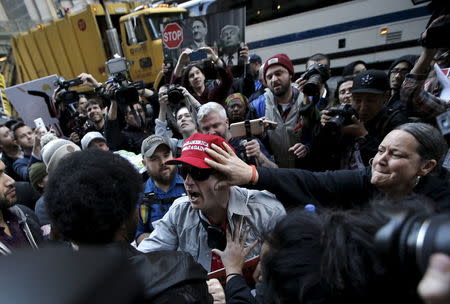 A supporter of Donald Trump (C) fights with protesters demonstrating against Donald Trump in midtown Manhattan in New York City, April 14, 2016. REUTERS/Mike Segar