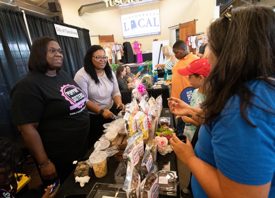 Shunetta Kirkman and co-owner of Poppin’ Sisters, Marleshia Hall, talk to patrons Jennifer Louie and her son, Jack Trainum, during the Celebrate Local event at Tuscaloosa River Market. The event allows local merchants to showcase their goods to the public.