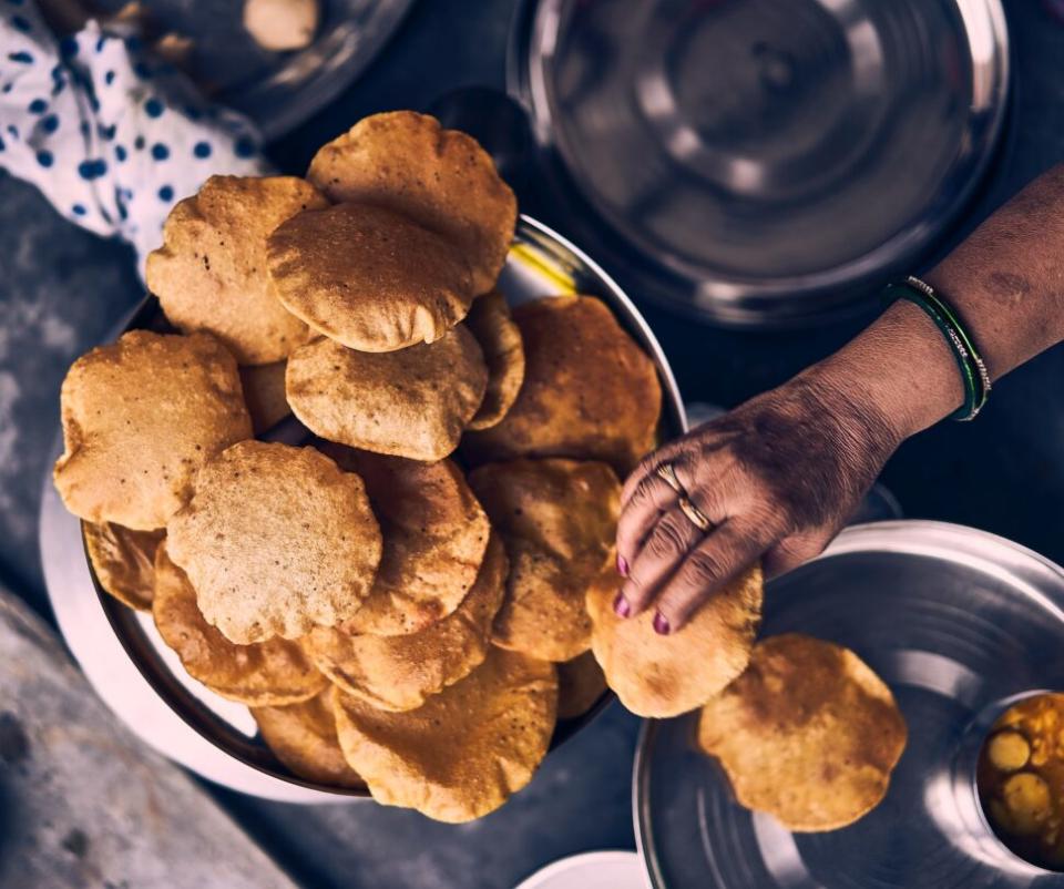 A woman serving Pooris

