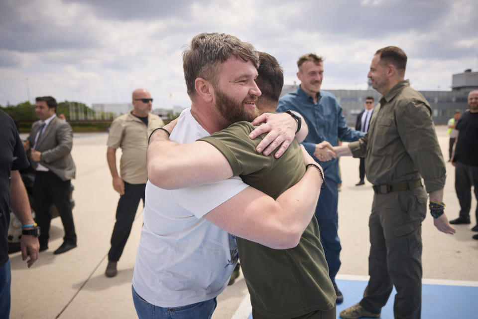 In this photo provided by the Ukrainian Presidential Press Office, Ukrainian President Volodymyr Zelenskyy, right, hugs with deputy commander of the Azov regiment Svyatoslav Palamar at Istanbul international airport in Istanbul, Turkey, Saturday, July 8, 2023. Five commanders of the defence of the Azovstal steel plant, a gruelling months-long siege early in the war, were returning from Turkey on the plane with Zelenskyy. (Ukrainian Presidential Press Office via AP)