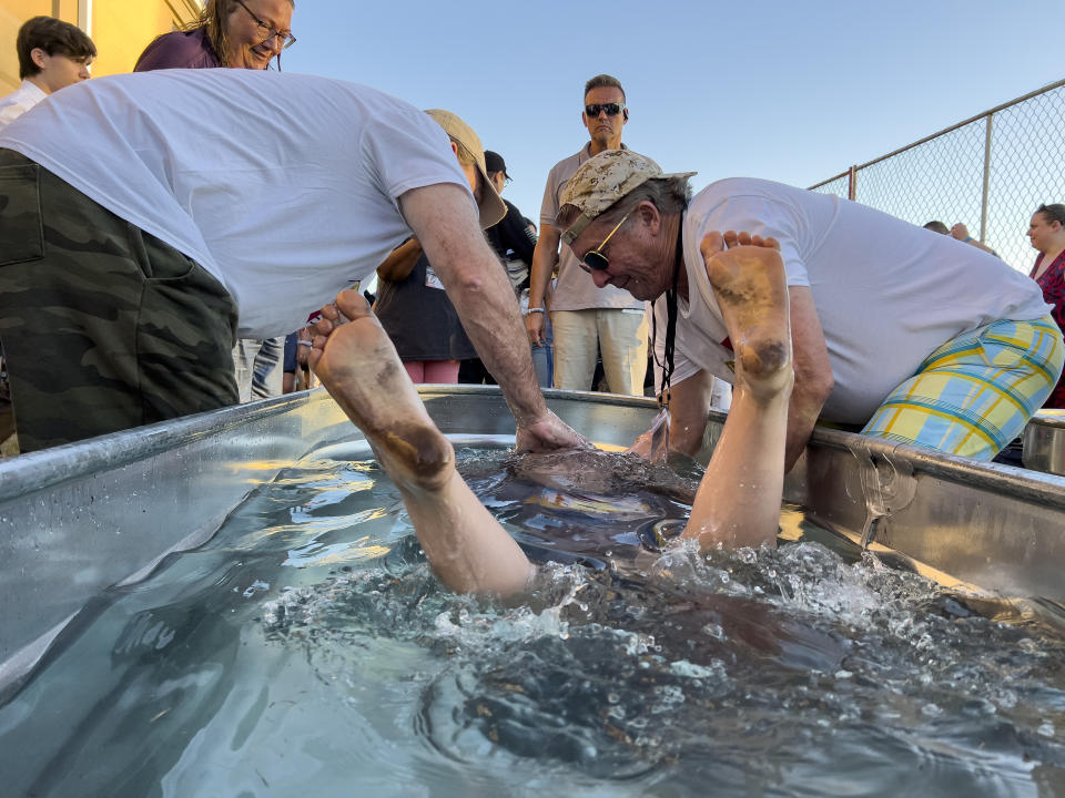 FILE - The bare feet of a girl shoot up from the water as she is baptized during the ReAwaken America Tour at Cornerstone Church in Batavia, N.Y., Aug. 12, 2022. (AP Photo/Carolyn Kaster, File)