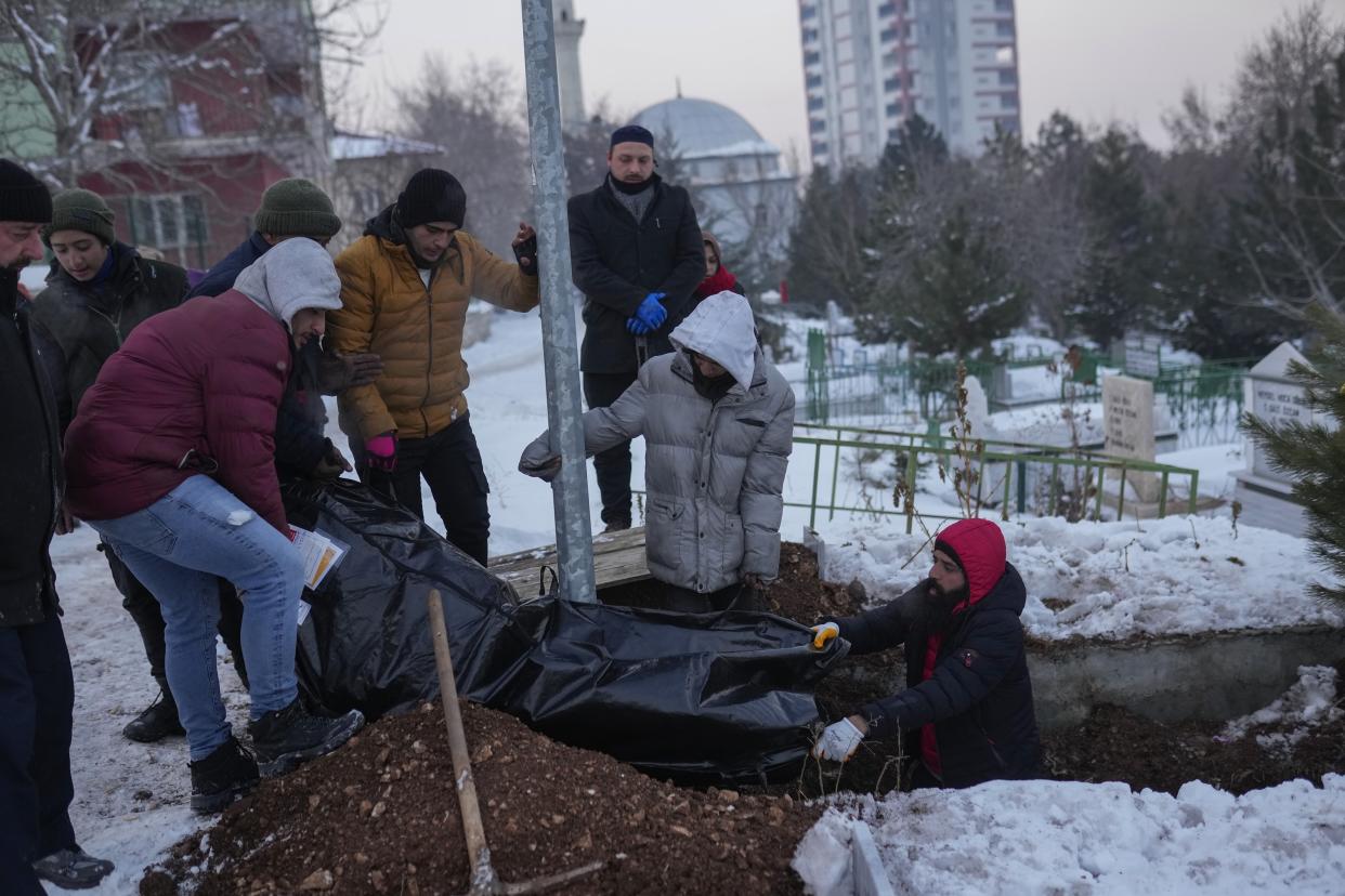 Relatives and friends of Syrian refugee Naziha Al-Ahmad bury her in a cemetery after she died during an earthquake, in Elbistan, southeastern, Turkey, Friday, Feb. 10, 2023. Rescuers pulled several earthquake survivors from the shattered remnants of buildings Friday, including some who lasted more than 100 hours trapped under crushed concrete after the disaster slammed Turkey and Syria. (AP Photo/Francisco Seco)