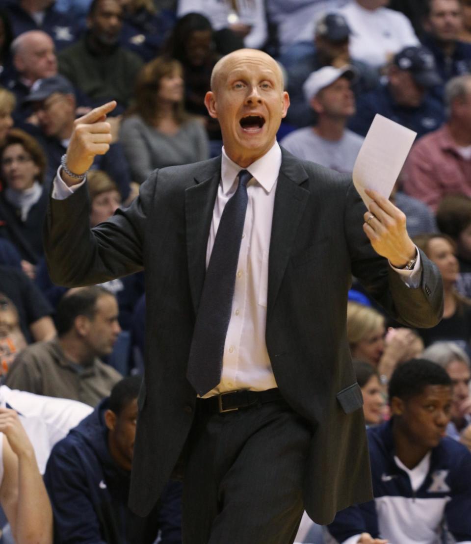 Xavier coach Chris Mack talks to his players during the first half of an NCAA college basketball game against Creighton in Cincinnati on Saturday March 1, 2014. (AP Photo/Tom Uhlman)