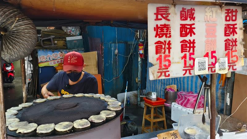 烤餅在烘烤時，需要人工反覆翻烤、完全不能停，過程中餅香不斷從黑色圓型的烤爐散出，正因老闆細心呵護著每一個酥餅，顧客才能享用到如此金黃酥脆，層次分明的酥餅。（圖／《阿鴻の美食散步》提供）