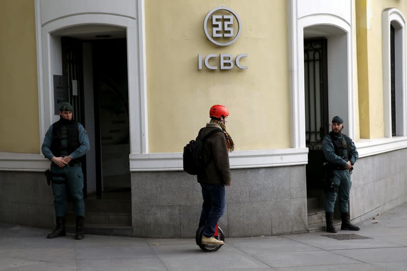 FILE PHOTO: A man rides a segway near Spanish Civil Guards at the headquarters of Industrial and Commercial Bank of China (ICBC) during a raid in Madrid