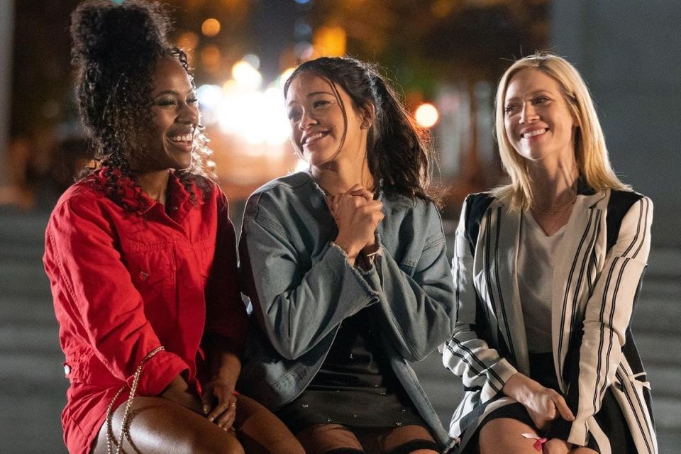 Jenny sitting with her two best friends and smiling