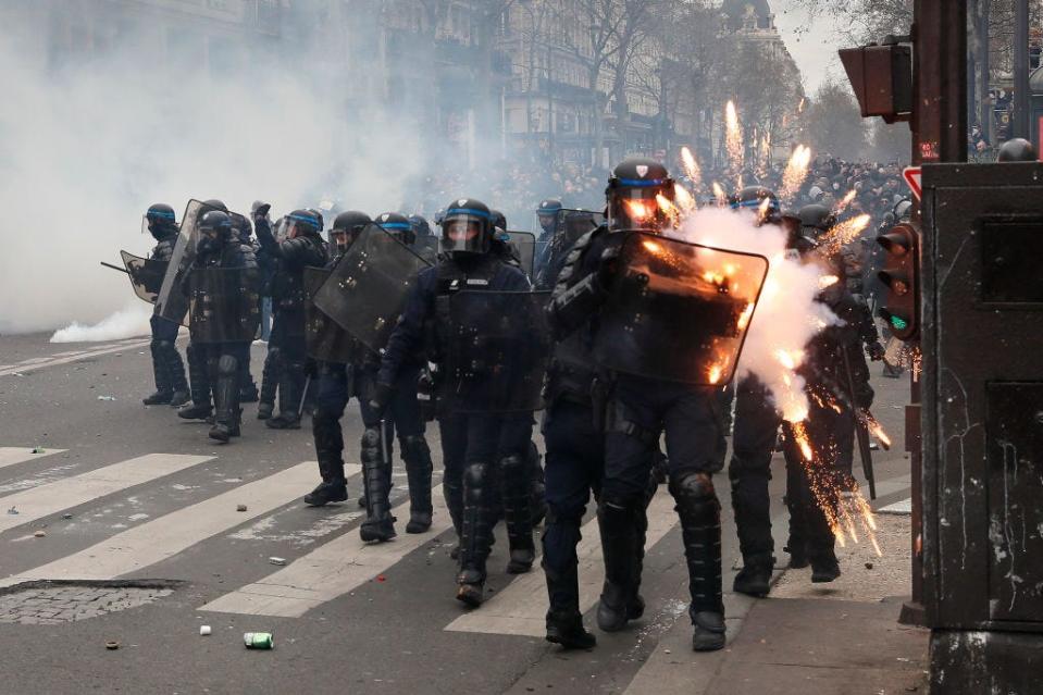 PARIS, FRANCE - MARCH 23: Riot police are struck by fireworks during violent clashes over the government's reform of the pension system on March 23, 2023 in Paris, France.