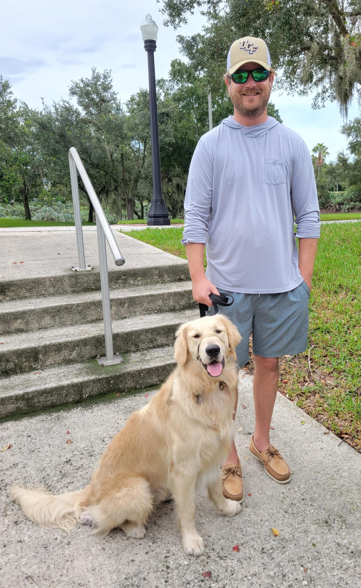 Dave Burt of St. Petersburg stands with his golden retriever, Trucks, outside Hyatt Place in Lakeland on Tuesday morning. Burt and his wife, Lindsey, evacuated as Hurricane Ian approached.