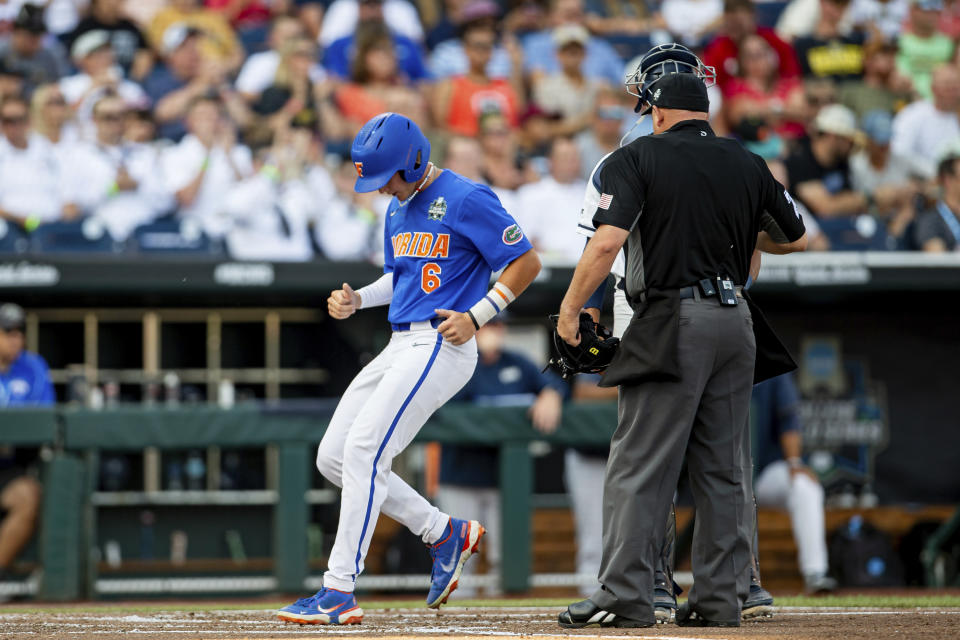 Florida runner Tyler Shelnut (6) scores on Ty Evans' home run in the second inning against Oral Roberts in a baseball game at the NCAA College World Series in Omaha, Neb., Sunday, June 18, 2023. (AP Photo/John Peterson)