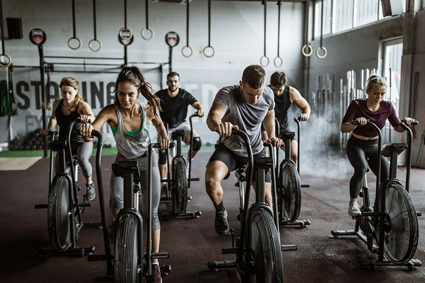 Grupo de gente entrenándose en bicicleta estática en el gimnasio