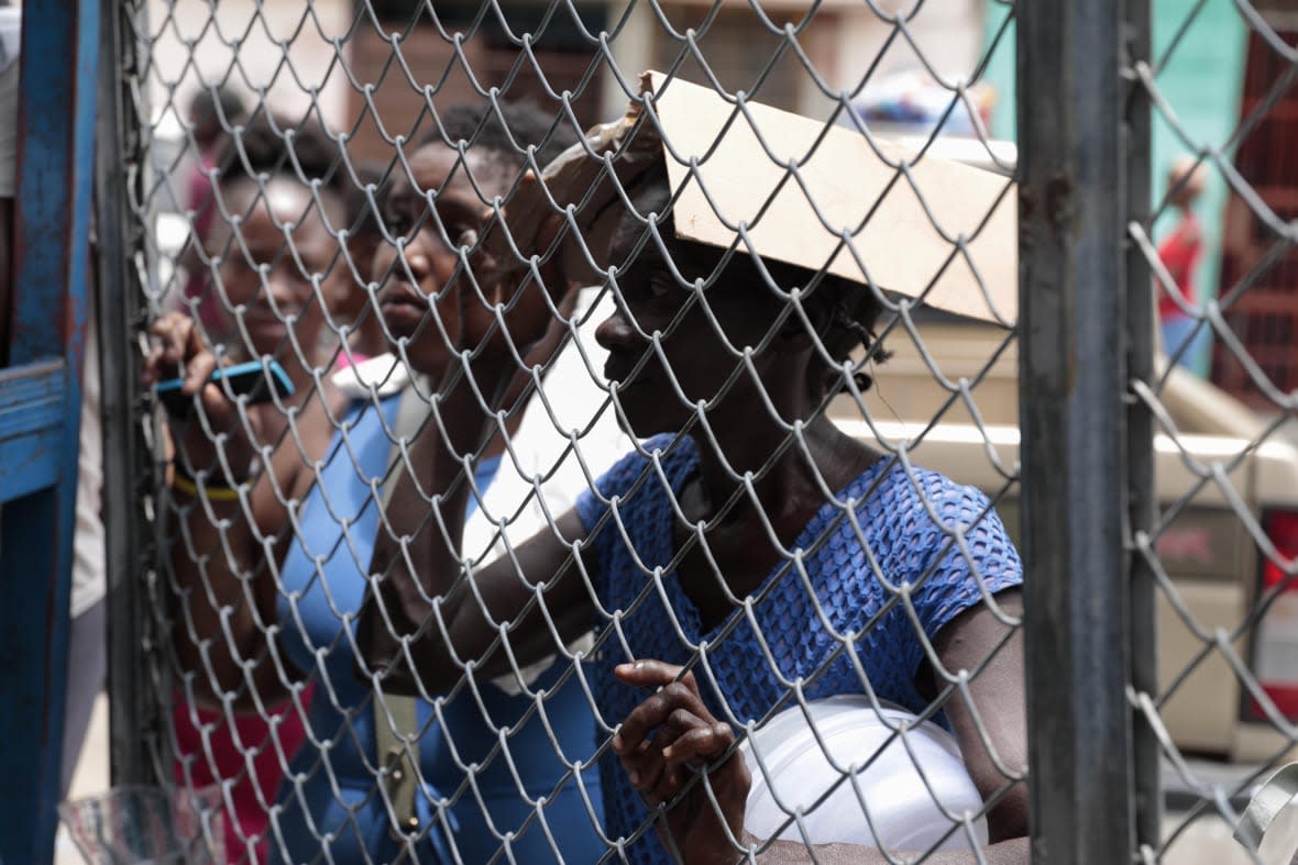 People gather outside the National Penitentiary for their turn to deliver food to their jailed relatives in downtown Port-au-Prince, Haiti, Thursday, June 1, 2023. In December 2022, the University of Florida published a study that found that men in Haiti’s prisons were on a starvation-level diet, consuming fewer than 500 calories a day. (AP Photo/Odelyn Joseph)