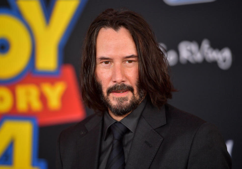 Keanu Reeves at the "Toy Story 4" premiere wearing a dark suit with a black tie