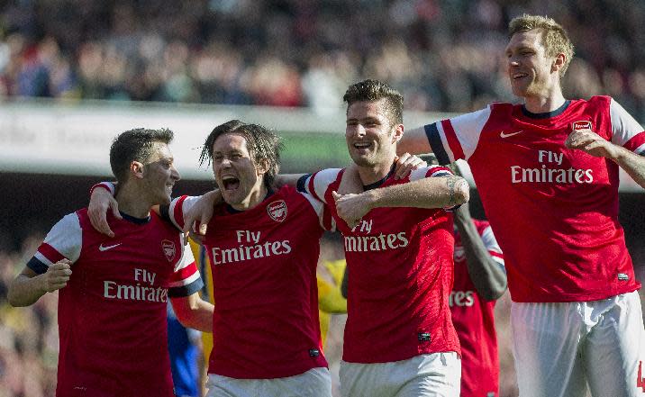 Arsenal's Olivier Giroud, second right, celebrates with teammates Mesut Ozil left, Tomas Rosicky, second left, and Per Mertesacker , right, after scoring against Everton, during their FA Cup quarterfinal soccer match, at Emirates Stadium, in London, Saturday, March 8, 2014. (AP Photo/Bogdan Maran)