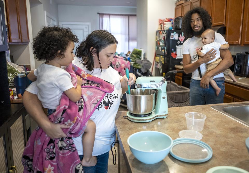 Rebecca Adamson holds Keiko while making a batch of chocolate cookies as Chris Watkins, holding Lucas, looks on. “I was always baking,” Adamson said. “I was always in the kitchen when my mom was making dinner. And I gravitated to desserts.”