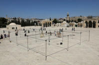 Visitors walk by as employees of the Jordanian Waqf, or Islamic trust, that oversees the area, build a structure during preparations for the Muslim holy month of Ramadan on the compound known to Muslims as al-Haram al-Sharif and to Jews as Temple Mount, in Jerusalem's Old City, May 6, 2017. REUTERS/Ammar Awad