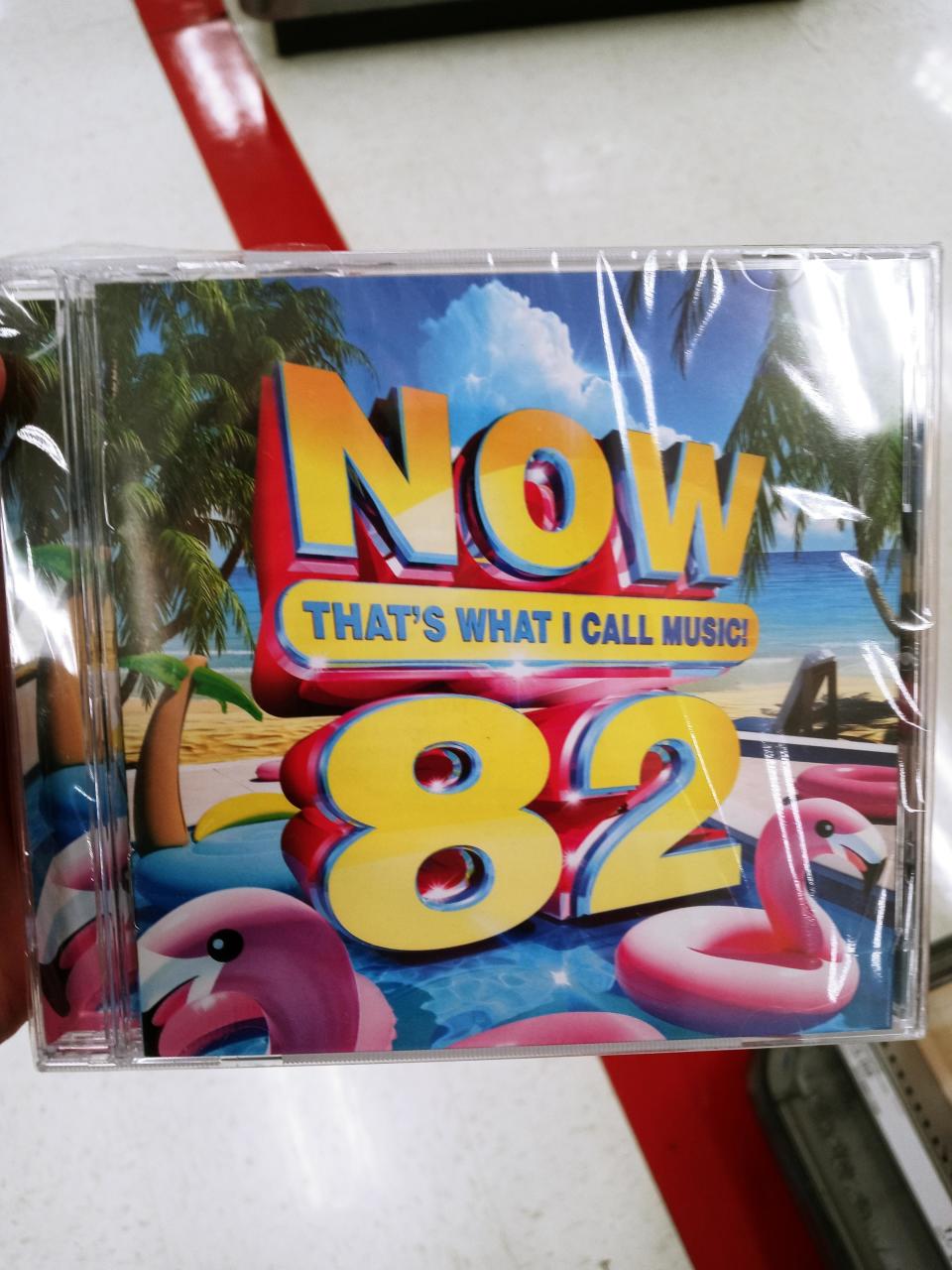 CD cover for 'NOW That’s What I Call Music 82' with large '82' and tropical graphics