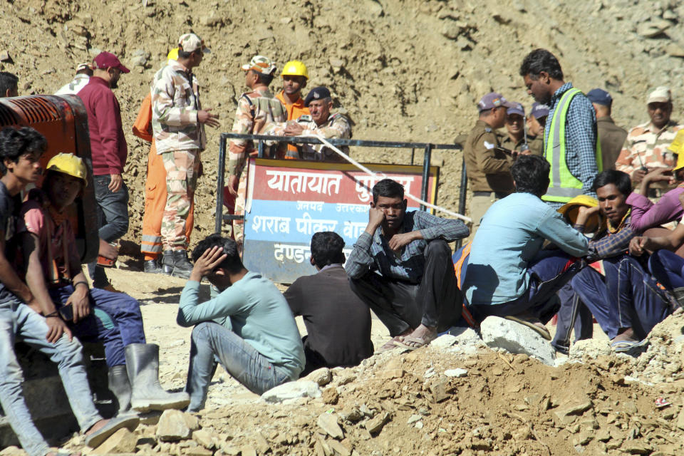 People watch rescue and relief operations at the site of an under-construction road tunnel that collapsed in mountainous Uttarakhand state, India, Wednesday, Nov. 15, 2023. Rescuers have been trying to drill wide pipes through excavated rubble to create a passage to free 40 construction workers trapped since Sunday. A landslide Sunday caused a portion of the 4.5-kilometer (2.7-mile) tunnel to collapse about 200 meters (500 feet) from the entrance. It is a hilly tract of land, prone to landslide and subsidence. (AP Photo)