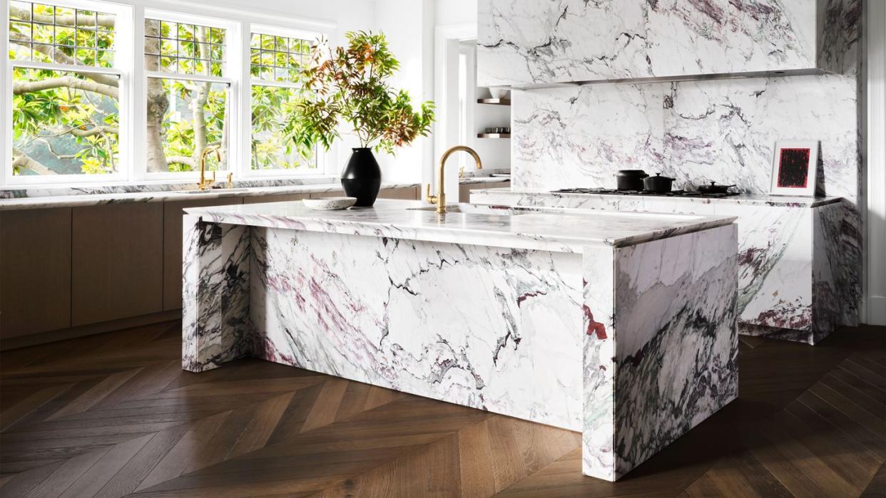 black and white marble kitchen with chevron pattern darkish wood flooring