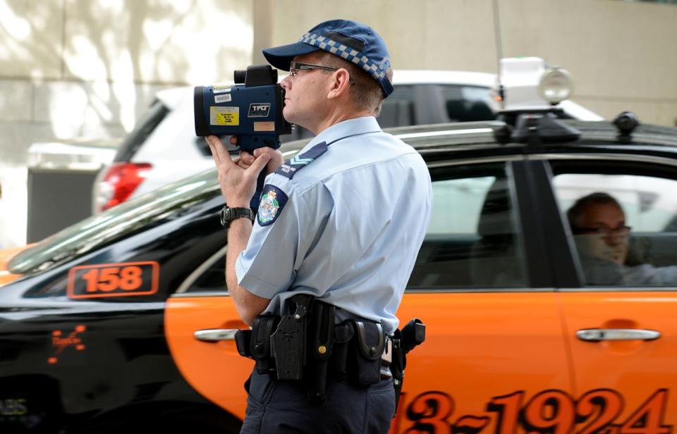 A NSW police officer with a speed gun radar. Double demerits apply in NSW, the ACT and Western Australia during the Easter long weekend.