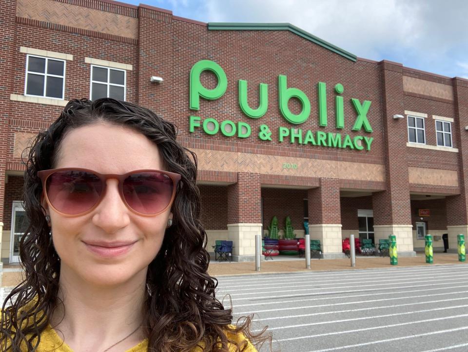 A woman in sunglasses standing outside a Publix supermarket