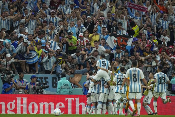 球迷欢呼，因为阿根廷球员在世界杯四分之一决赛中庆祝进球。