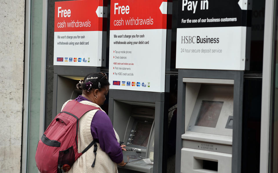 A person uses a cash machine at a HSBC branch in London as the banking giant is to cut between 22,000 and 25,000 jobs globally including a reported 8,000 in the UK as part of an overhaul to slash costs and reshape the business.