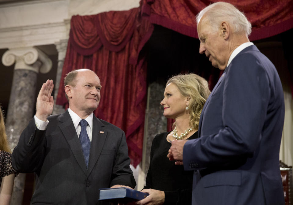 FILE - In this Jan. 6, 2015, file photo, Vice President Joe Biden administers the Senate oath to Sen. Chris Coons, D-Del., as Coons' wife, Annie Coons, watches during a ceremonial re-enactment swearing-in, in the Old Senate Chamber on Capitol Hill in Washington. When Coons speaks to the Democratic National Convention on Thursday, Aug. 20, before Biden’s speech accepting the party’s presidential nomination, his remarks will focus on faith — attesting in highly personal fashion to his longtime friend’s belief in God. (AP Photo/Jacquelyn Martin, File)